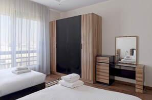 A hotel room with a bed, a wardrobe, a desk, and a mirror. - Vesta - Luxury apt - 2BR - CFC XII (New Cairo)