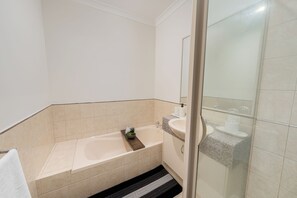 Ein Badezimmer mit einer Badewanne, einem Waschbecken und einer Duschkabine.