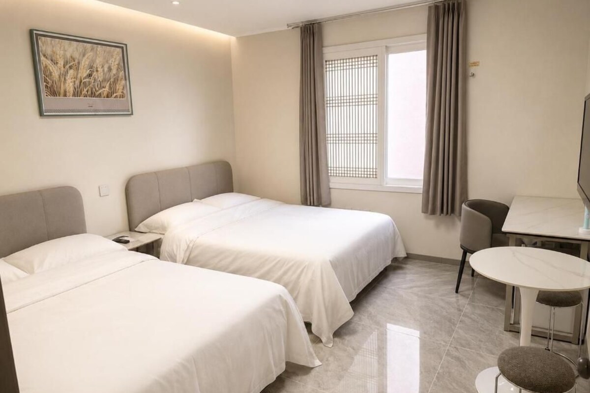 Une chambre d’hôtel avec deux lits, une table à manger et une chaise.