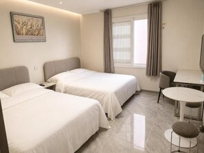 Une chambre d’hôtel avec deux lits, une table à manger et une chaise.