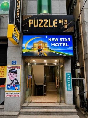 La entrada de un hotel con un cartel que dice 'New Star Hotel' y una puerta visible.
