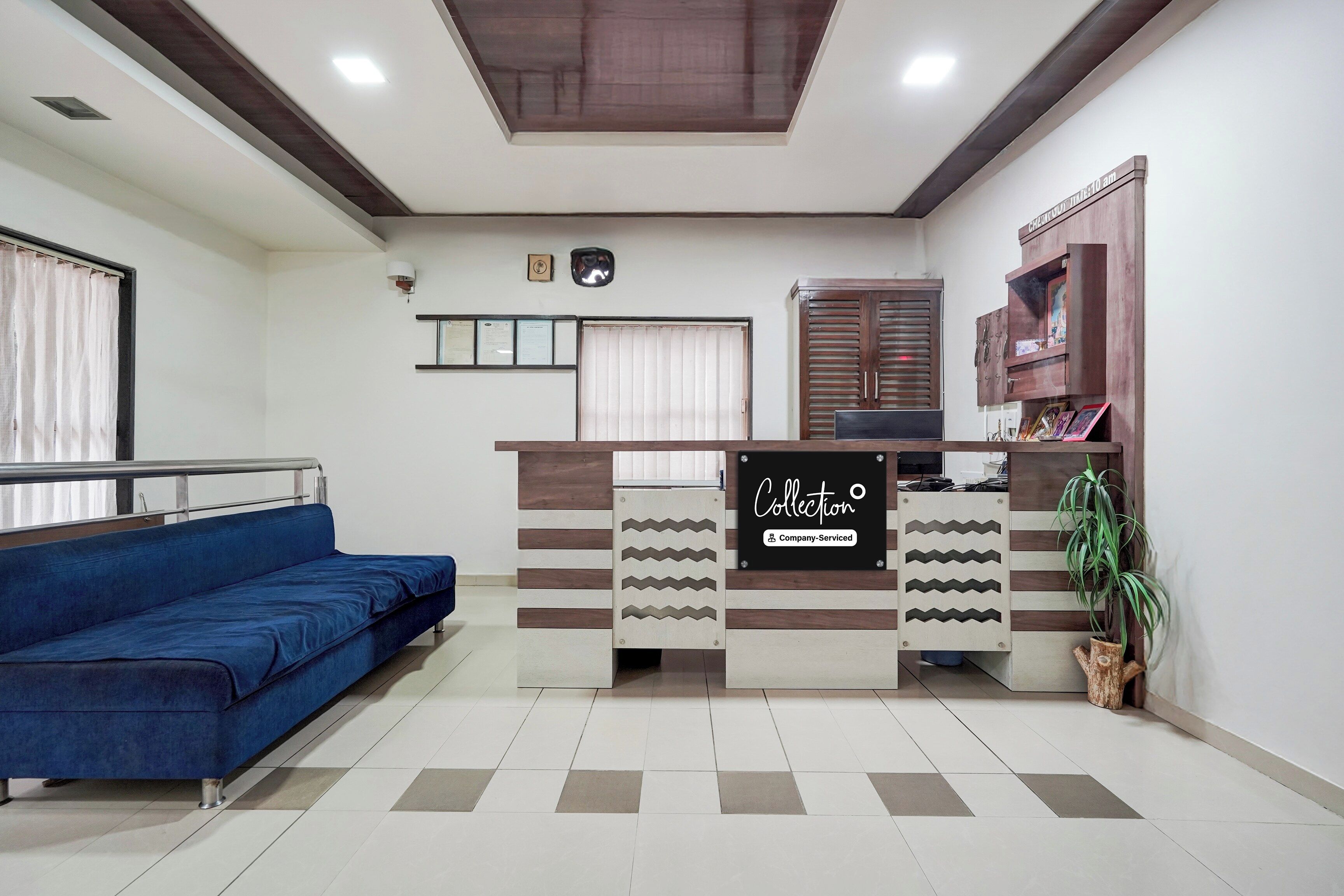 Un área de recepción con un sofá azul, un mostrador y un mueble de pared.