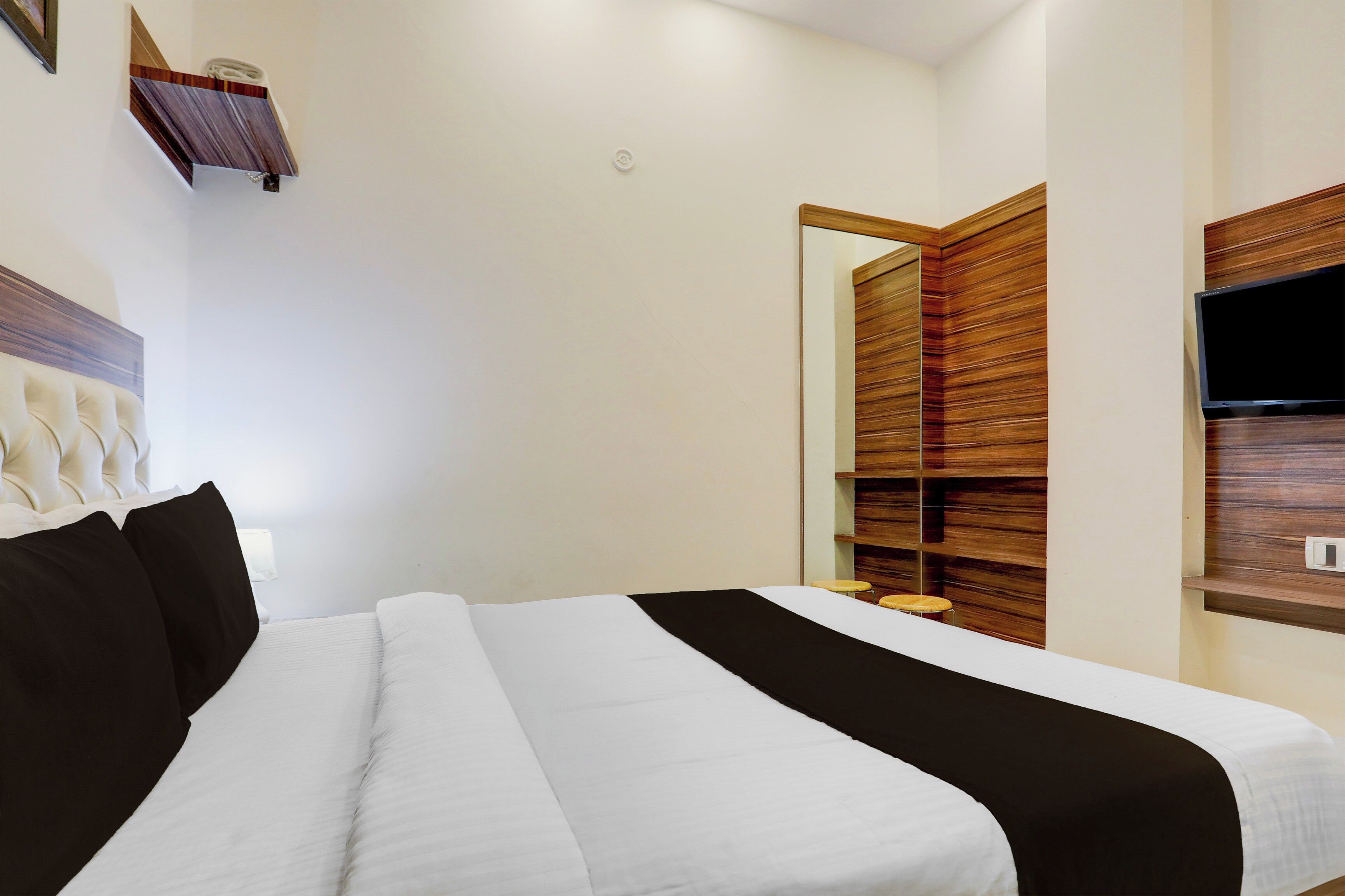 Ein Hotelzimmer mit einem Bett, einem Fernseher und einer Wand mit Holzverkleidung.