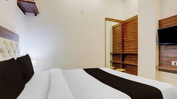 Ein Hotelzimmer mit einem Bett, einem Fernseher und einer Wand mit Holzverkleidung.