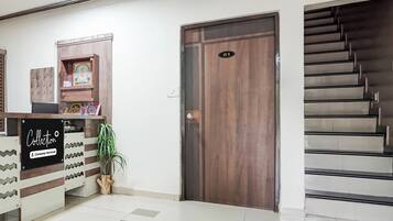 A reception area with a wooden door marked '01', a reception desk with a sign 'Collection Company-Serviced', and a staircase to the right.