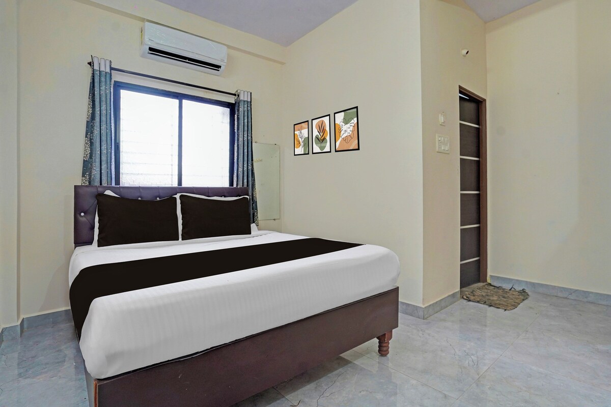 A bedroom with a bed, an air conditioning unit, a window with curtains, and a door to a closet.