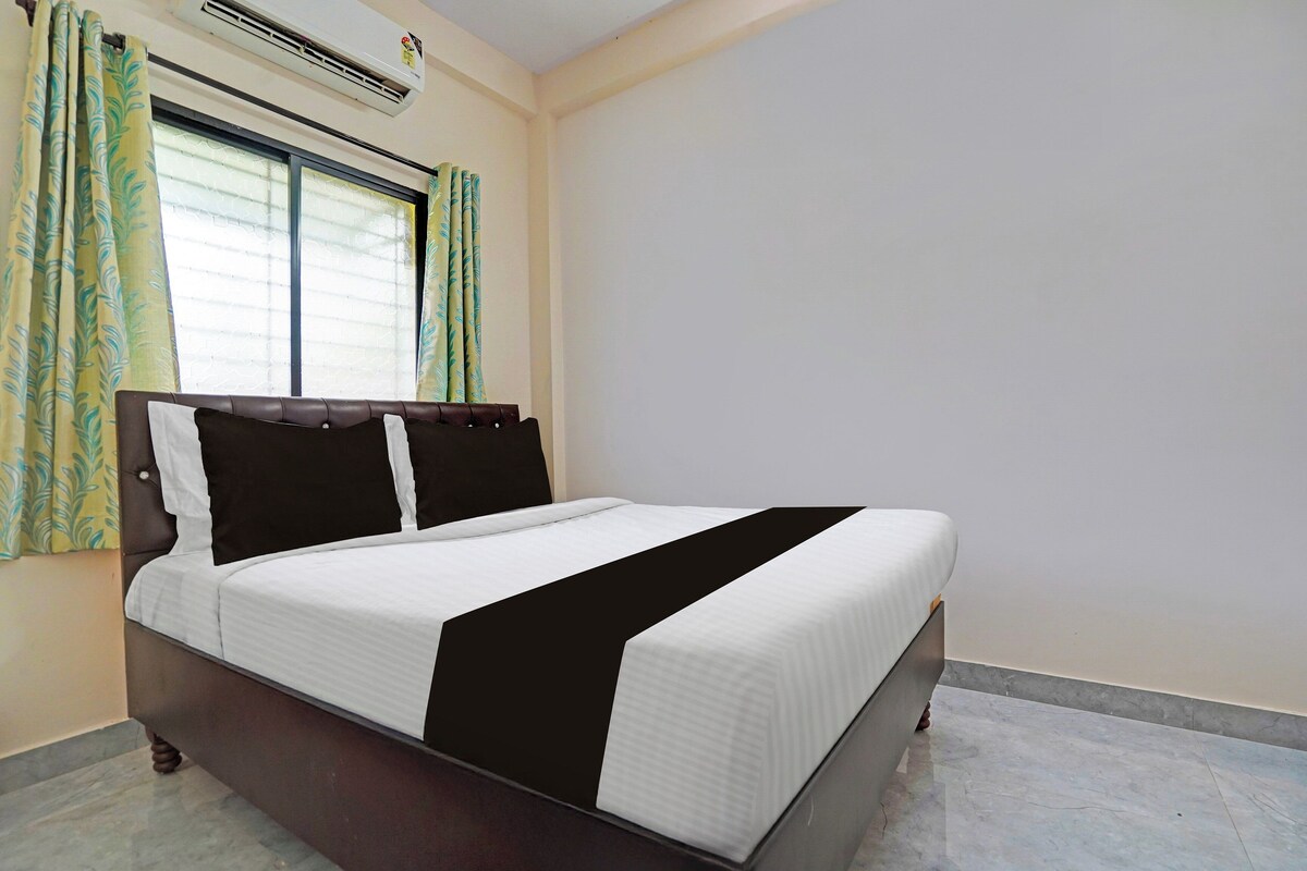 A bed with a headboard, a window with blinds, and a wall-mounted air conditioner.
