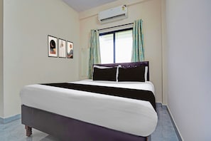A hotel room with a bed, an air conditioner, a window with curtains, and framed artwork on the wall. - Hotel O CRPF Crossway (Hingna)