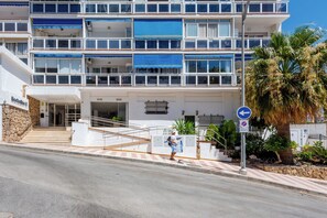 A multi-story hotel with a staircase leading to the entrance, a blue awning over the windows, and a palm tree in the foreground. - Al Andalus Torremolinos – Bright Coastal Apartment near La Carihuela, Restaurants & Centre (Torremolinos)