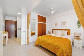 A bedroom with a bed, a nightstand, a mirror, and a door. - Al Andalus Torremolinos – Bright Coastal Apartment near La Carihuela, Restaurants & Centre (Torremolinos)