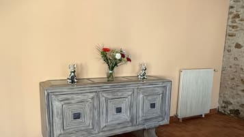 Una habitación con un mueble grande y decorativo en una pared, un radiador y suelo de baldosas.