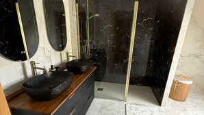 A modern bathroom with a black marble vanity, two sinks, a large mirror, and a glass-enclosed shower. - Cottage 'L’échappée Bleue De Marguerite' with private pool, terrace and Wi-Fi (Évron)