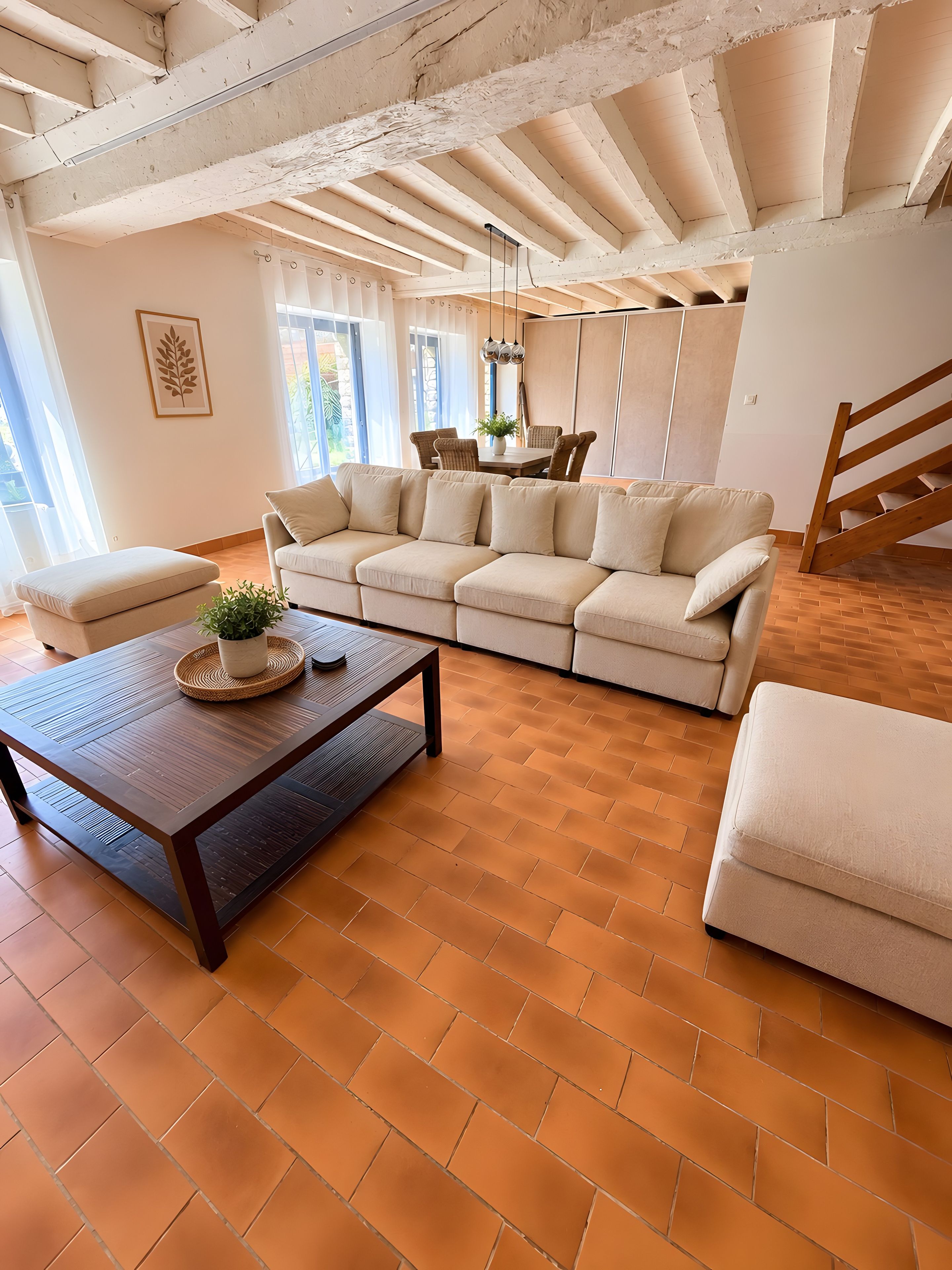A spacious living room with a sectional sofa, a wooden coffee table, and a staircase.