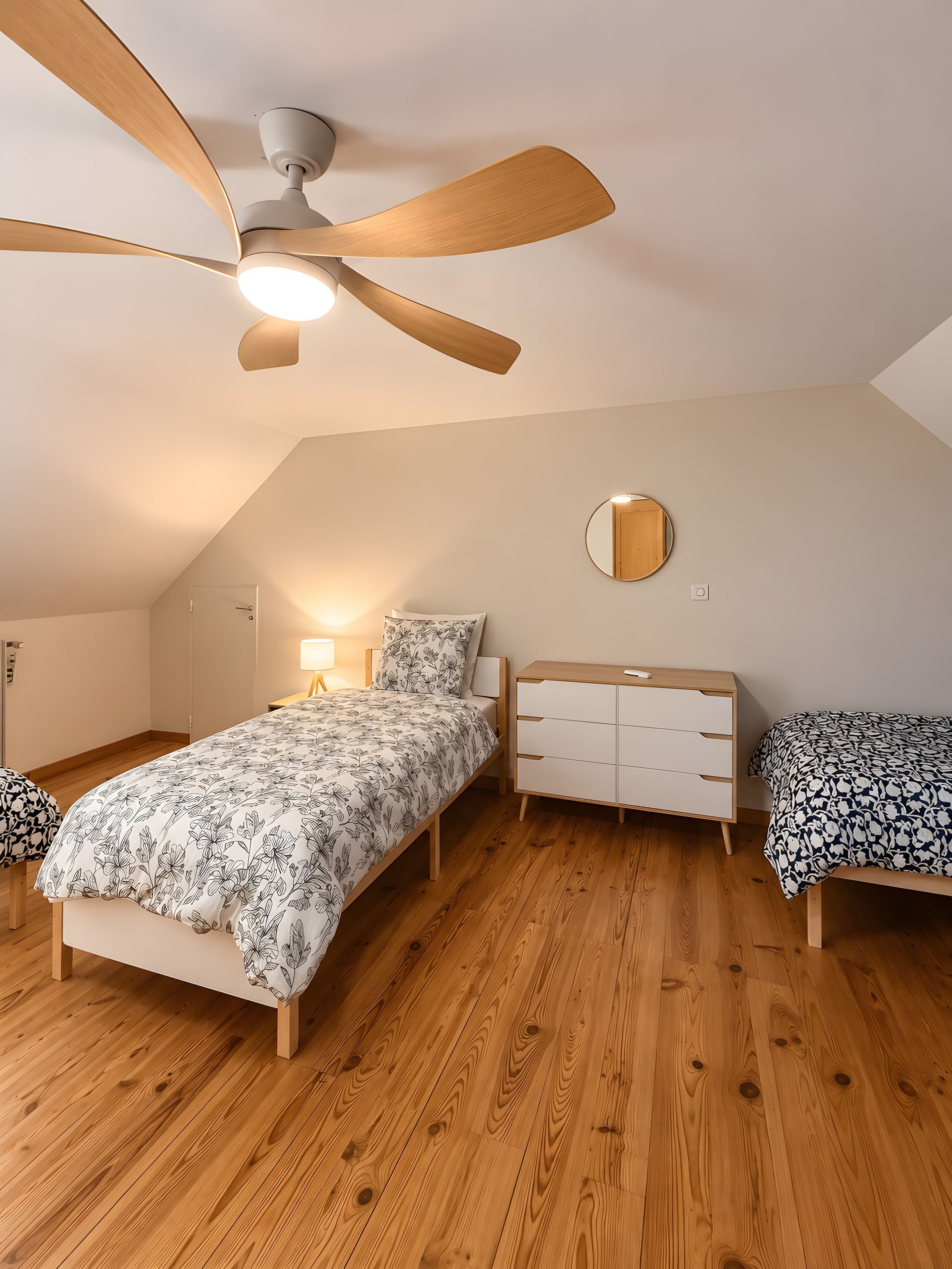 Ein Schlafzimmer mit einem Bett, einem Nachttisch, einer Kommode, einem Deckenventilator und einem runden Spiegel.