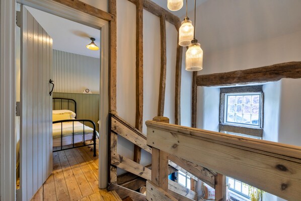 Eine Holztreppe mit Blick auf ein Schlafzimmer.