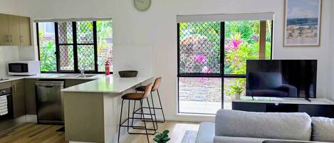 A modern living space with a kitchen, dining area, and seating.