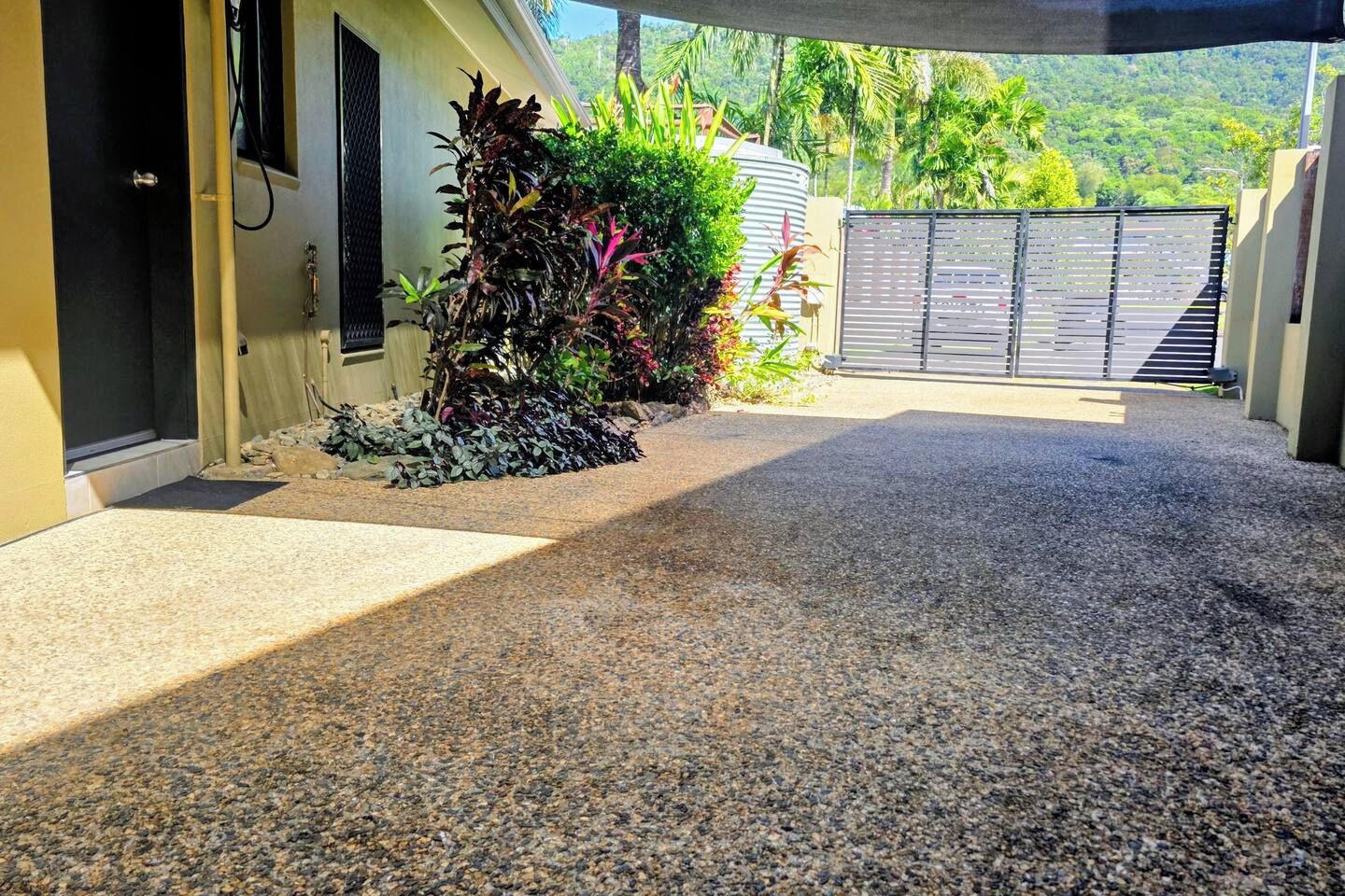 A covered driveway leading to a building with a gated entrance.