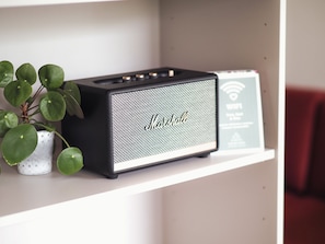 A black Marshall amplifier on a white shelf with a small potted plant beside it. - Chesa Montana - Top 206 (Maria Alm am Steinernen Meer)