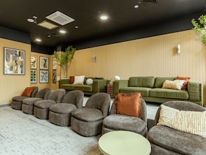 Ein moderner Lounge-Bereich mit Sofas, Poufs und einem Couchtisch.