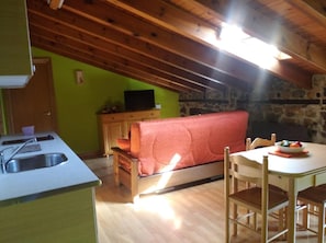 A compact living space with a kitchenette, a sofa, and a dining area.