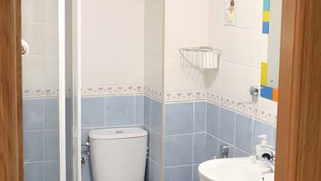 Un baño con ducha, inodoro y lavabo.