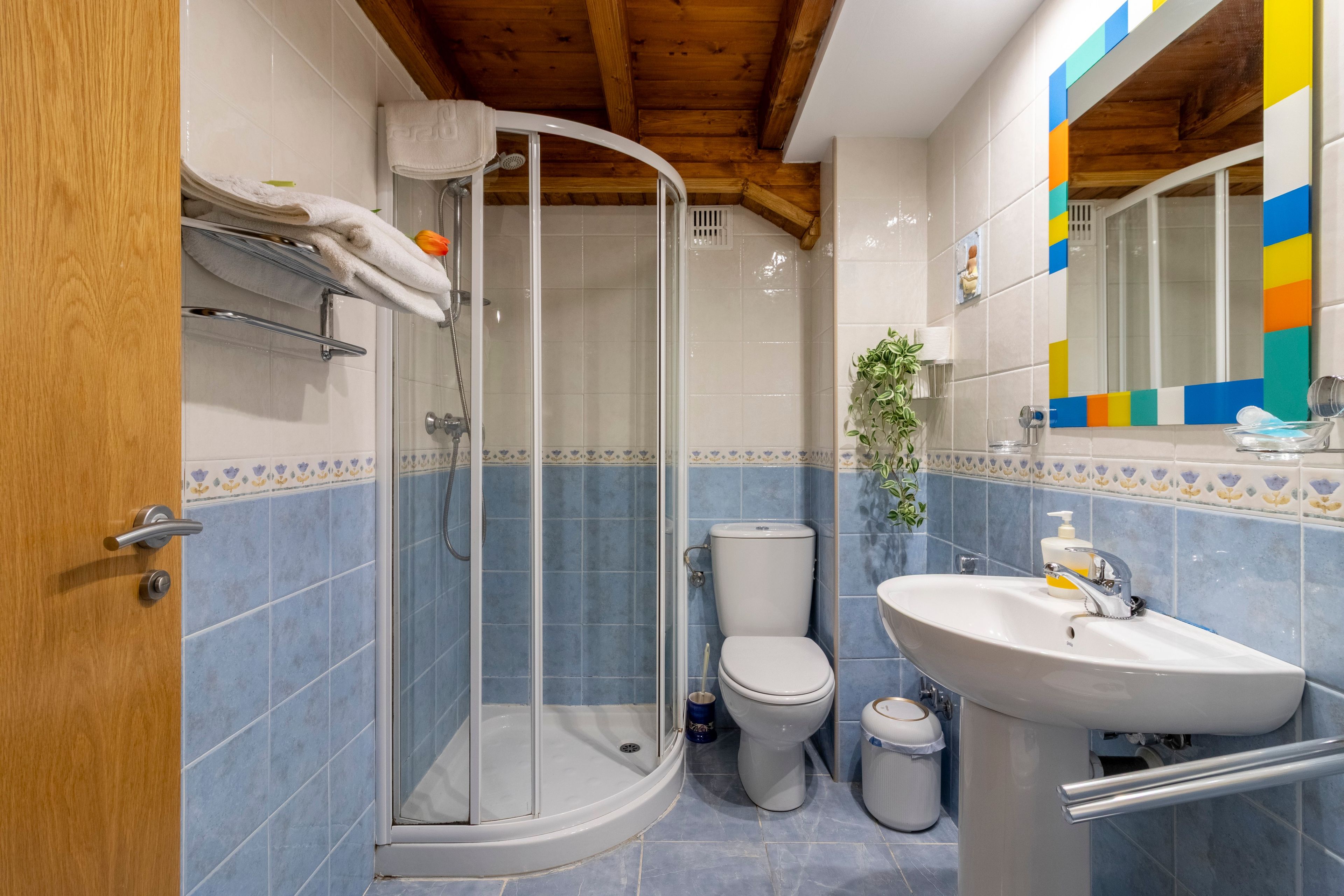 Een badkamer met douche, toilet en wastafel.
