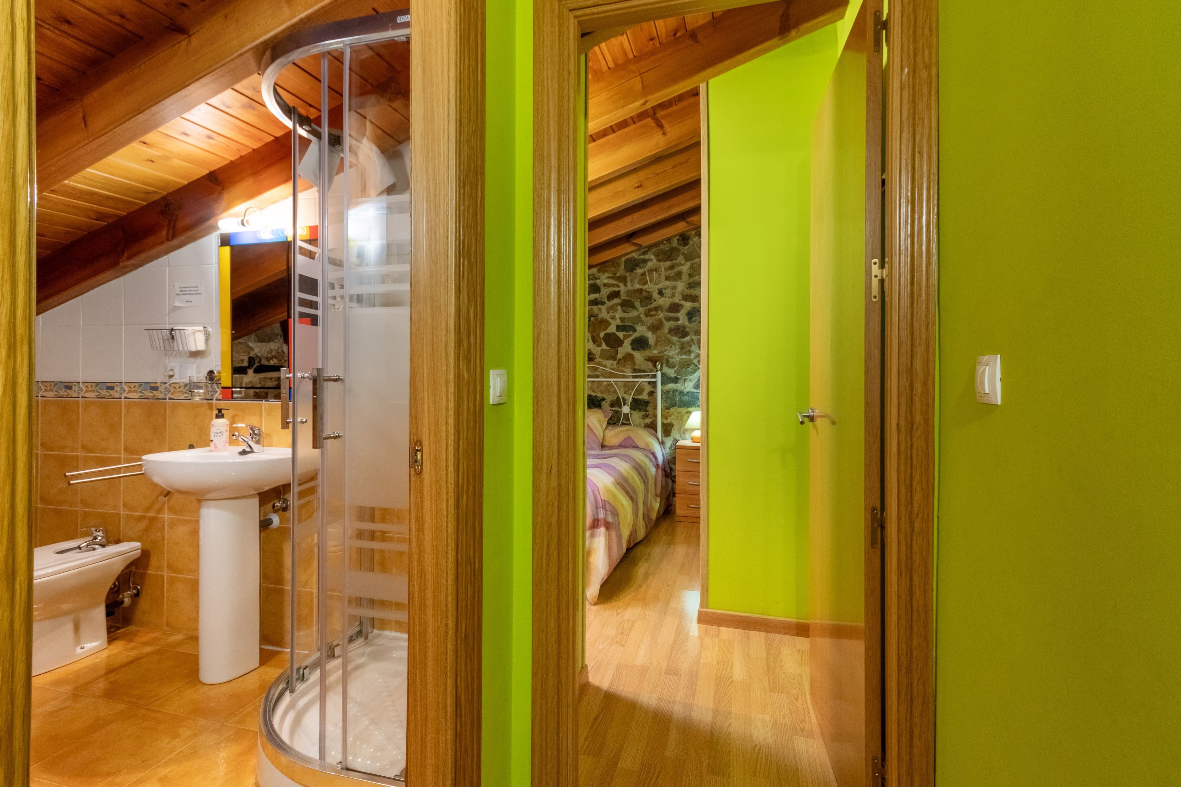 Un baño con cabina de ducha de vidrio, un lavamanos y un inodoro.