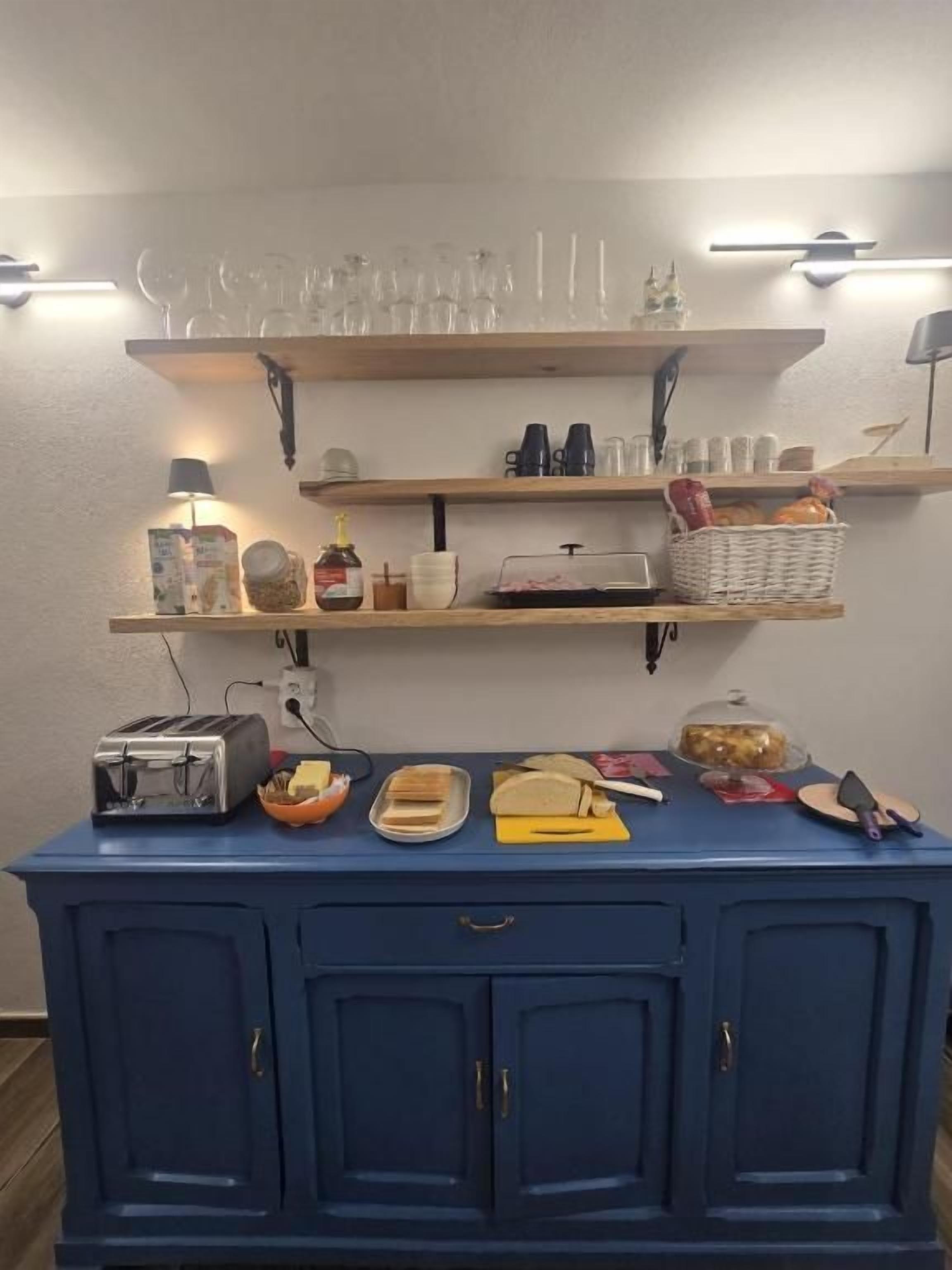 A kitchen counter with a toaster, bread, and a basket of bread.