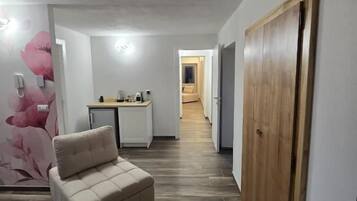 A hallway with a sofa, a wooden wardrobe, and a small table with items on it.