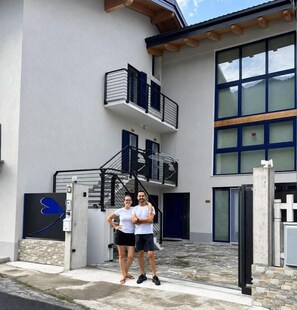A two-story building with a staircase, a gated entrance, and a large window.