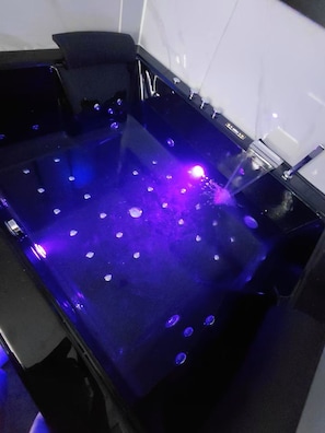 Eine Badewanne mit einer Wasserstrahlfunktion und LED-Beleuchtung.