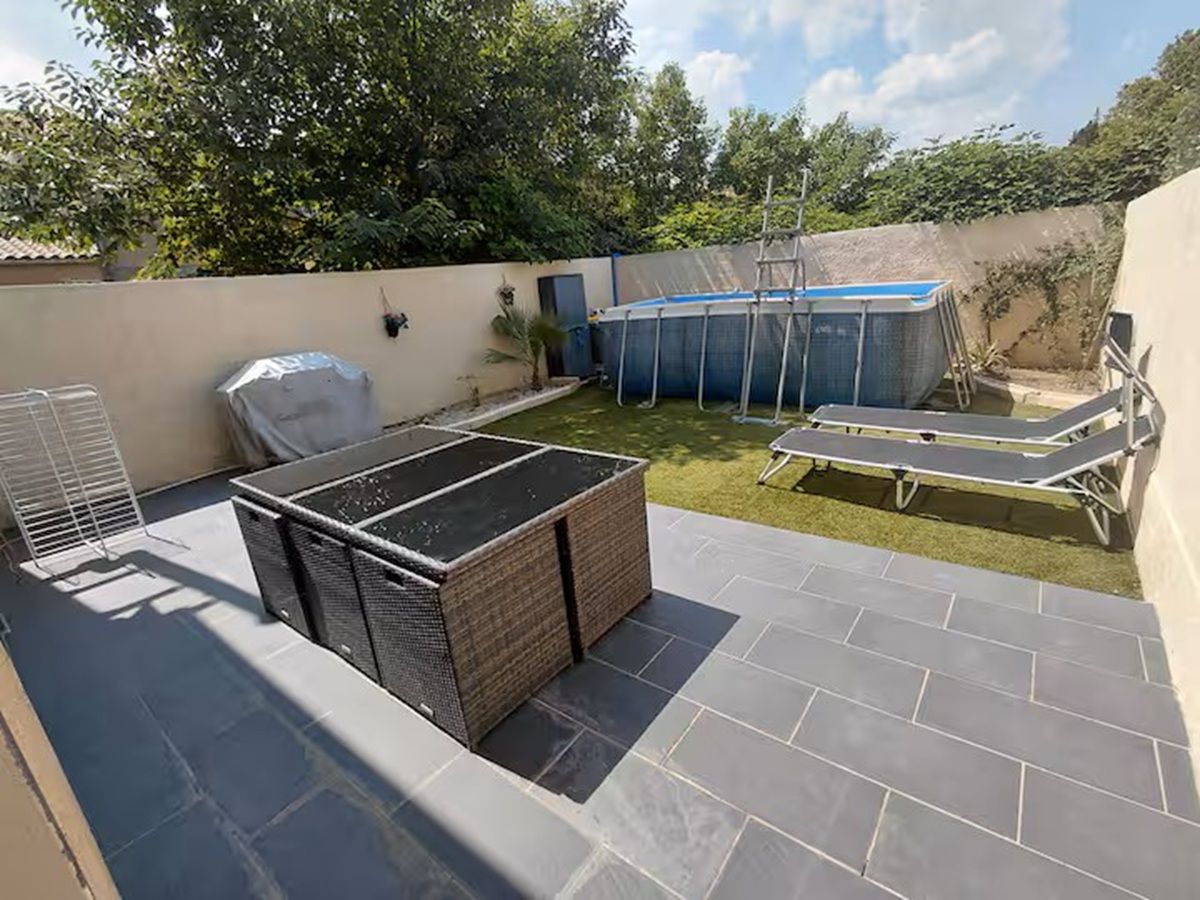 Une terrasse sur le toit dotée d’un espace salon couvert, d’une petite piscine et d’une chaise longue.
