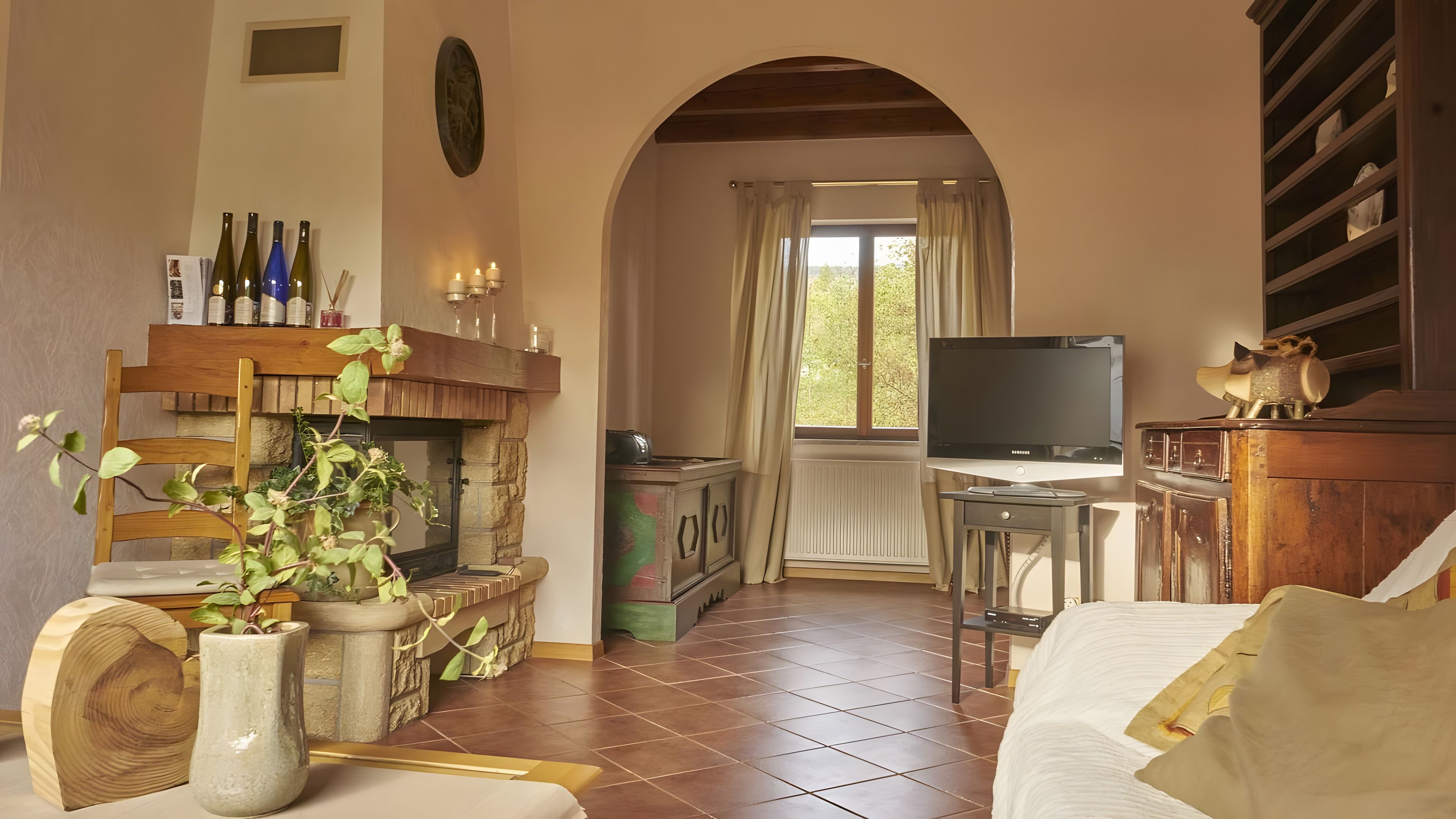 Een gezellige woonkamer met een open haard, een televisie en een eethoek.