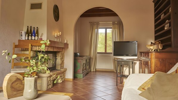 A cozy living room with a fireplace, a television, and a dining area.