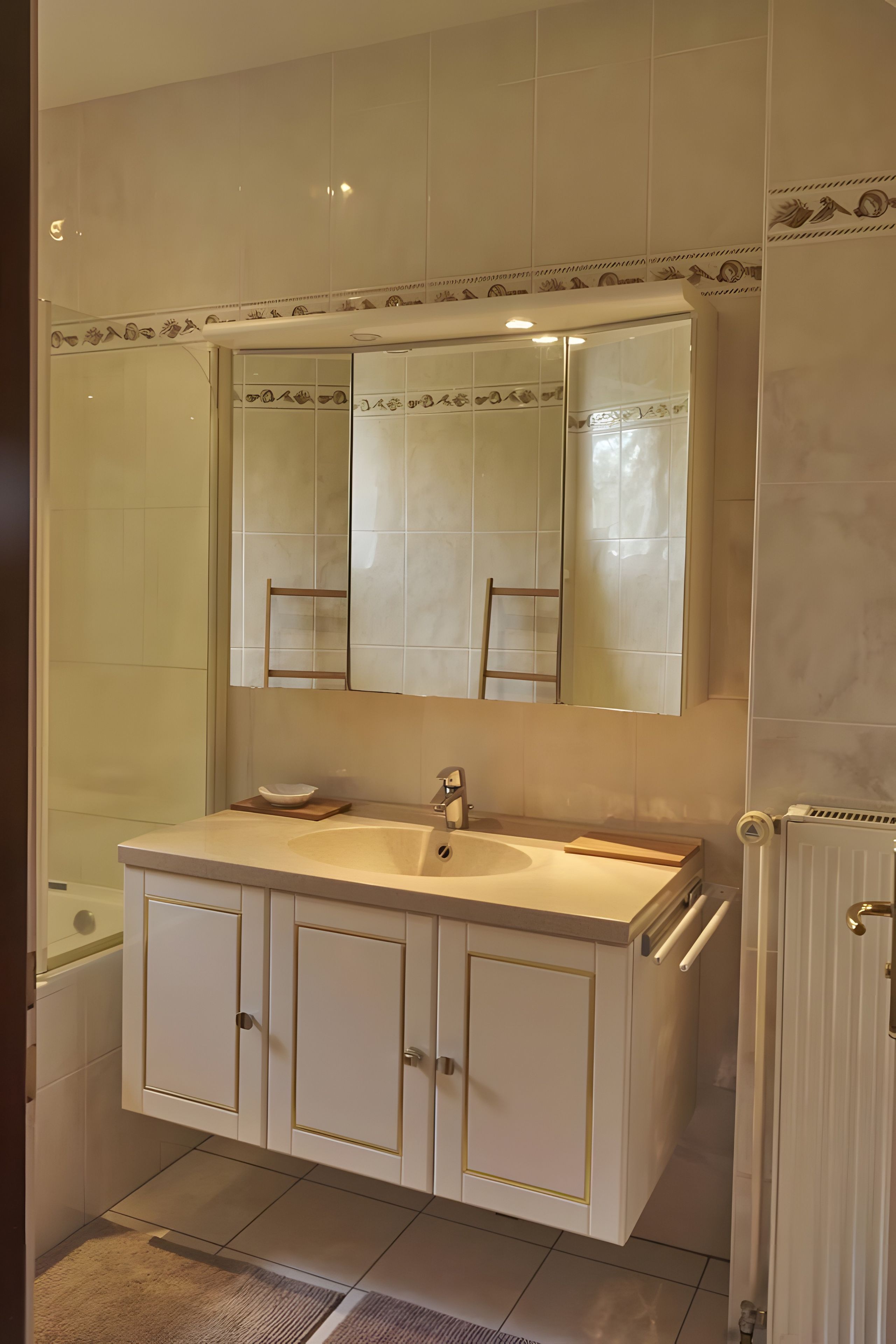 A bathroom with a white vanity, a mirror, and a bathtub.