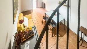 Escada que leva a uma sala de jantar com mesa e cadeiras.