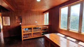 Un interior de madera con una larga mesa y una estantería.