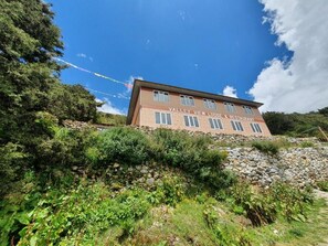 Un edificio con un cartel que dice 'Valley View Lodge & Restaurant', rodeado de follaje y un cielo despejado.