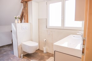Un baño pequeño con inodoro, lavamanos y ventana.