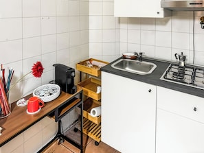 A compact kitchen with a coffee maker, a sink, and a stove. - Le Dimore - Potenza. (Potenza)