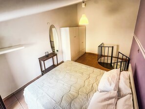 A bedroom with a bed, a bedside table, a mirror, a wardrobe, and a hanging light fixture. - Le Dimore - Potenza. (Potenza)