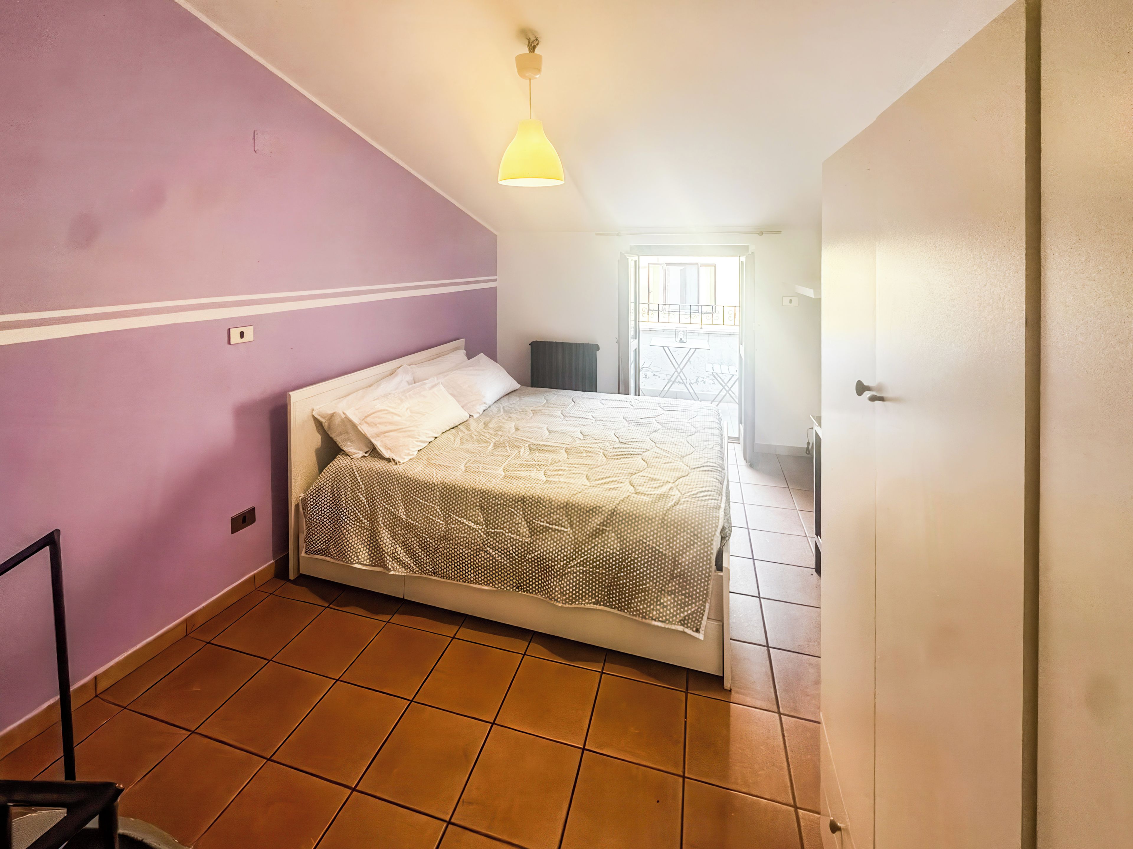 Une chambre à coucher avec un lit, une fenêtre et une porte.