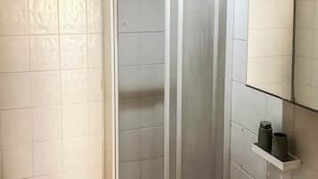 A bathroom with a toilet, sink, and shower enclosure.