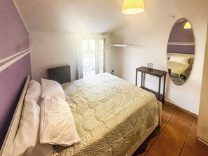 A hotel room with a bed, a small table, a mirror, and a view of the outside. - Le Dimore - Potenza. (Potenza)