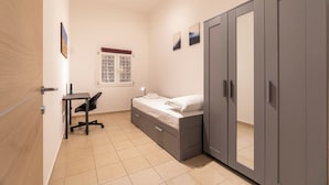 A bedroom with a bed, a desk, and a wardrobe. - Achillini 9 (Bologna)