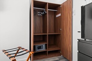 Ein Holzschrank mit mehreren Einlegeböden, einer Kleiderstange und einem kleinen Tresor.