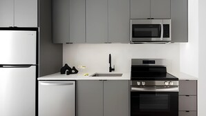 A modern kitchen with a built-in microwave, oven, and dishwasher. - Miles at Ybor - Tampa (Tampa)