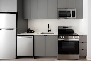 A modern kitchen with a built-in microwave, oven, and dishwasher. - Miles at Ybor - Tampa (Tampa)