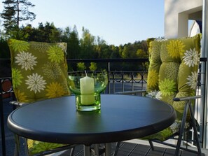 A round table with a candle on it, surrounded by two chairs with floral upholstery. - Apartment in Balm With Swimming Pool (Benz)