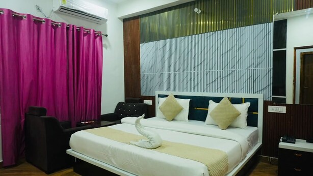 Une chambre d’hôtel avec un lit, une chaise, un bureau et une fenêtre avec des rideaux.